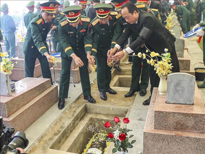 Lãnh đạo tỉnh Điện Biên và lực lượng vũ trang thực hiện nghi thức an táng hài cốt các liệt sĩ quân tình nguyện Việt Nam tại Nghĩa trang liệt sĩ Tông Khao. Ảnh: Xuân Tư - TTXVN