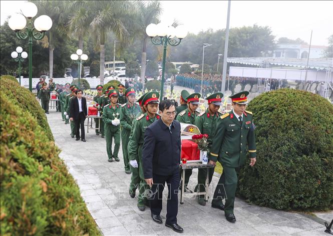 Đại biểu, chiến sĩ đưa hài cốt liệt sĩ về an táng tại Nghĩa trang liệt sĩ Tông Khao. Ảnh: Xuân Tư - TTXVN