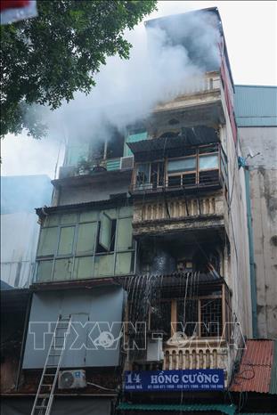 10h30, khói vẫn bốc lên tại tầng 5 nhà 14 phố Hàng Mã. Ảnh: Hoàng Hiếu - TTXVN