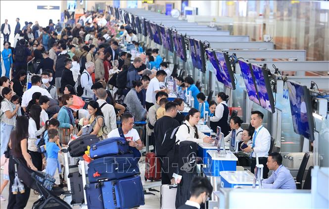 Đông nghẹt người dân, du khách nước ngoài làm thủ tục tại quầy của hãng hàng không Vietnam Airlines, sân bay quốc tế Nội Bài, ngày 31/12. Ảnh: Quốc Khánh - TTXVN
