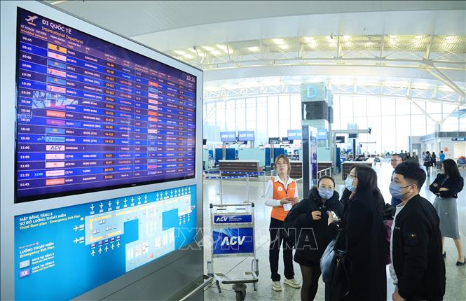 Du khách tìm kiếm thông tin chuyến bay nội địa ngày 31/12, tại sân bay quốc tế Nội Bài. Ảnh: Quốc Khánh - TTXVN