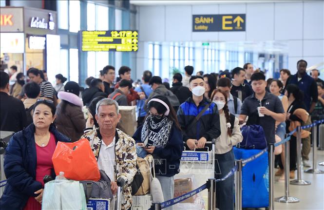 Người dân và du khách xếp hàng chờ làm thủ tục sáng 31/12 tại sân bay quốc tế Nội Bài. Ảnh: Quốc Khánh - TTXVN