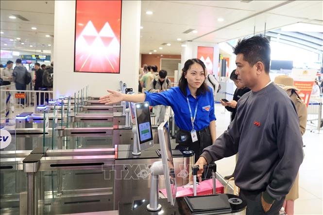 Lực lượng tình nguyện viên Cảng hàng không quốc tế Nội Bài hướng dẫn người dân và du khách tại cửa vào phòng chờ lên máy bay. Ảnh: Quốc Khánh - TTXVN