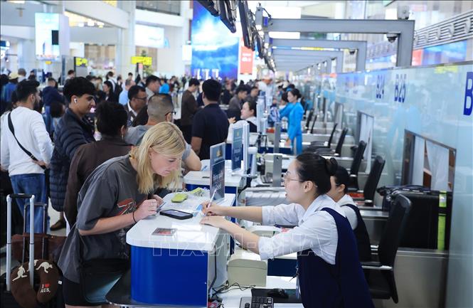 Du khách nước ngoài làm thủ tục nối chuyến nội địa đến các điểm du lịch tại Việt Nam sáng 31/12 tại sân bay quốc tế Nội Bài. Ảnh: Quốc Khánh - TTXVN