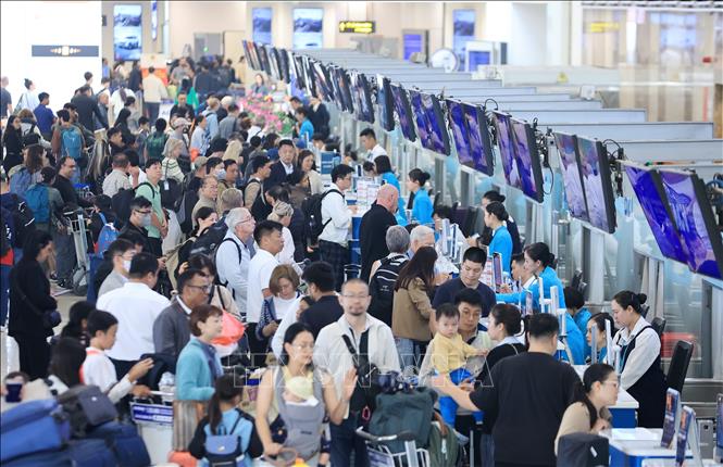 Đông nghẹt người dân, du khách nước ngoài làm thủ tục tại quầy của hãng hàng không Vietnam Airlines, sân bay quốc tế Nội Bài, ngày 31/12. Ảnh: Quốc Khánh - TTXVN
