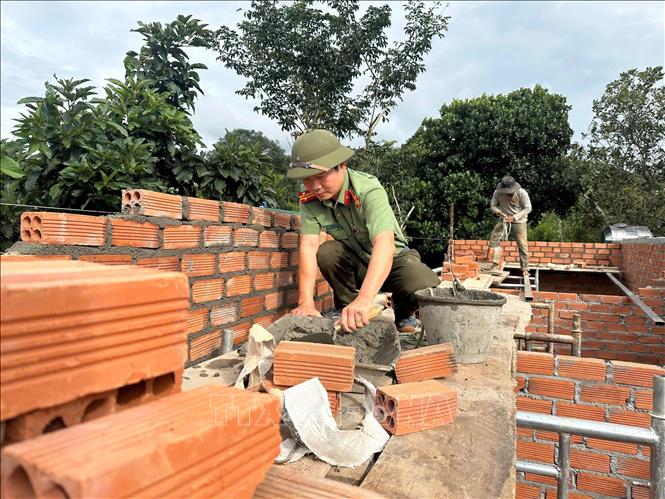 Cán bộ Công an Lâm Đồng xây dựng nhà cho dân trong Chương trình xóa nhà tạm, nhà dột nát ở các xã biên giới Lâm Đồng. Ảnh TTXVN phát