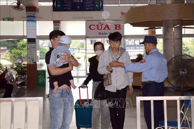 Hành khách ra khu vực đậu xe tại Bến xe miền Đông, chờ đến giờ khởi hành. Ảnh: Tiến Lực - TTXVN