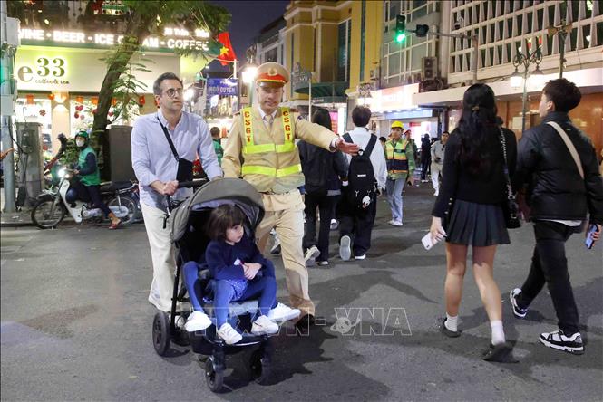 Cán bộ, chiến sĩ đội CSGT số 1 hướng dẫn du khách quốc tế vui Tết Dương lịch 2026. Ảnh: Phạm Kiên - TTXVN