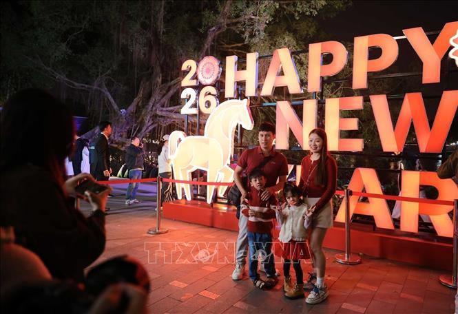 People take photos on Hoan Kiem Lake of Hanoi on the New Year's Eve night. VNA Photo