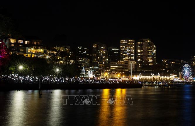 Những người tham gia lễ hội đã dành một phút mặc niệm trong khi bật đèn điện thoại để thể hiện sự đoàn kết với cộng đồng Do Thái. Ảnh: THX/TTXVN