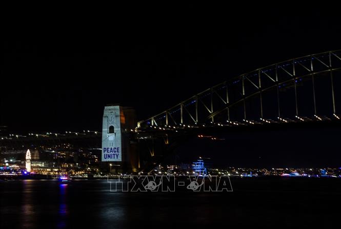 Một giờ trước khi đồng hồ điểm thời khắc chuyển giao, cây cầu cảng nổi tiếng của Sydney sáng rực màu trắng với những trụ cầu mang hình đèn menorah, một loại giá cắm nến thiêng liêng của người Do Thái. Ảnh: THX/TTXVN