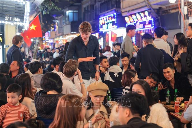 Khu vực các phố quanh Hồ Gươm như Lương Ngọc Quyến, Tạ Hiện... đón nhiều du khách nước ngoài tới vui chơi, thưởng thức ẩm thực, chờ đón năm mới 2026. Ảnh: Hoàng Hiếu - TTXVN