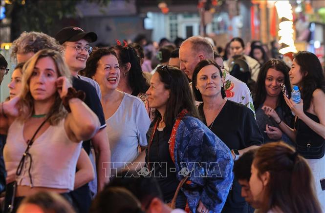 Du khách thích thú khi hoà mình vào không khí chờ đón năm mới 2026 tại khu vực phố cổ quanh hồ Hoàn Kiếm. Ảnh: Hoàng Hiếu - TTXVN