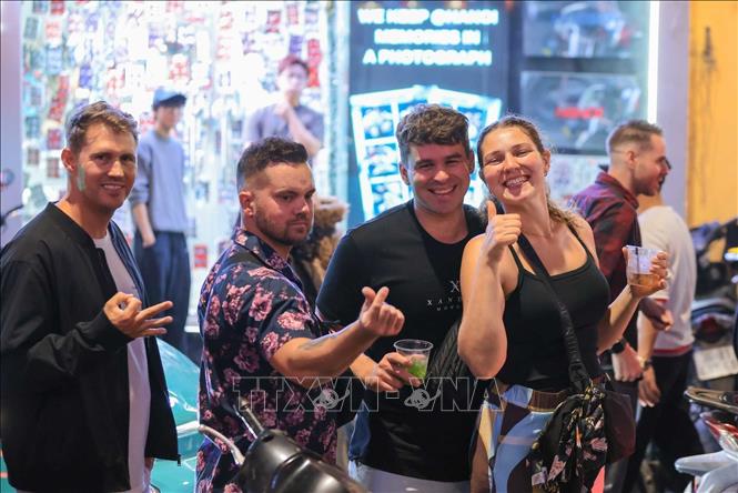 Du khách nước ngoài thích thú hoà mình vào khoảnh khắc chuyển giao năm mới trong không gian phố cổ Hà Nội. Ảnh: Hoàng Hiếu - TTXVN