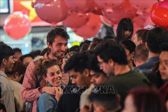 Niềm vui của du khách khi hoà mình vào không khí chờ đón năm mới 2026 tại khu vực phố cổ quanh hồ Hoàn Kiếm. Ảnh: Hoàng Hiếu - TTXVN