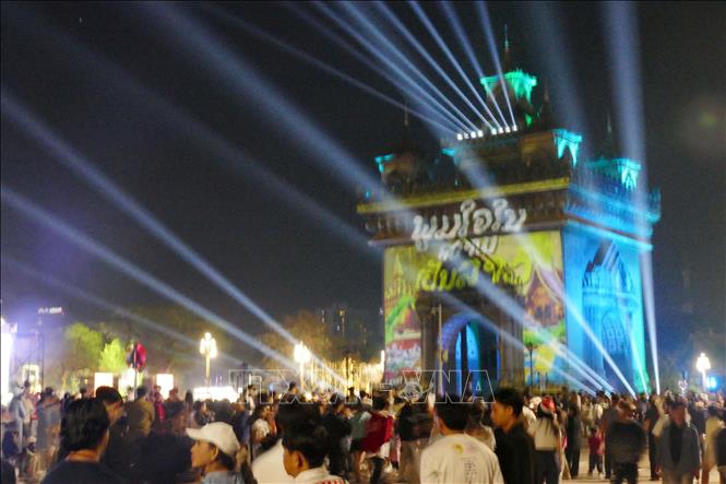 Màn trình chiếu hình ảnh màu sắc trực tiếp lên tháp Patouxay với dòng chữ “Tự hào là người Lào”. Ảnh: Xuân Tú - PV TTXVN tại Lào