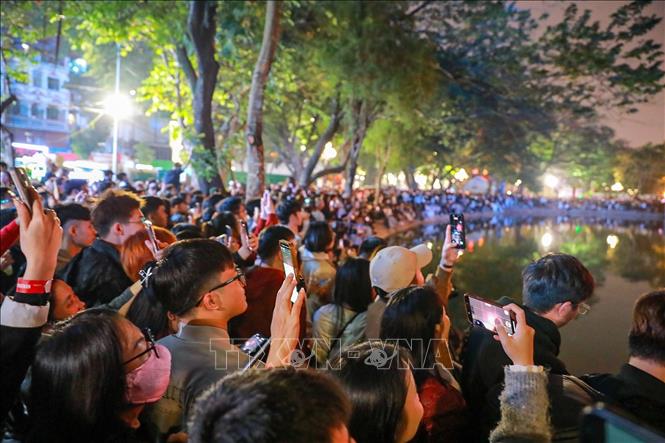 Rất đông người dân tập trung quanh Hồ Hoàn Kiếm theo dõi màn pháo hoa chào đón Năm mới 2026. Ảnh: Khánh Hoà - TTXVN