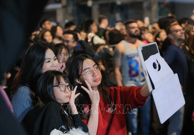 Lưu giữ kỷ niệm trong thời khắc chuyển giao giữa năm 2025 sang năm mới 2026. Ảnh: Hoàng Hiếu - TTXVN