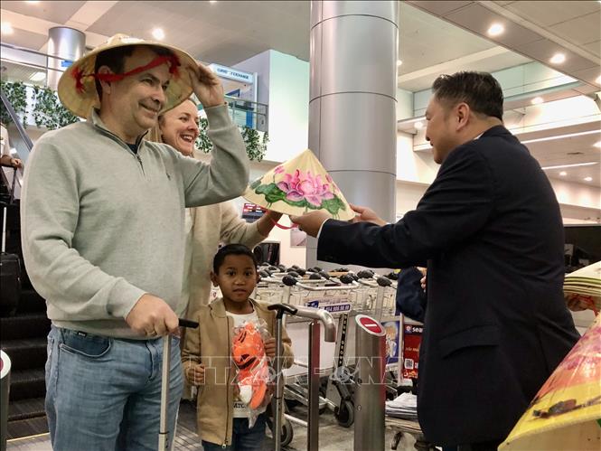 Du khách bất ngờ nhận những món quà đặc trưng của Việt Nam. Ảnh: Mỹ Phương - TTXVN.