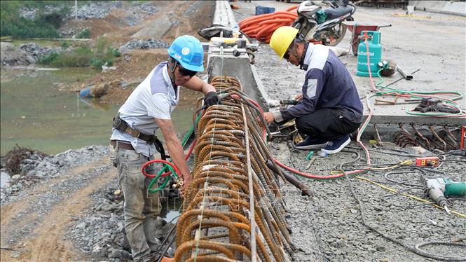 Công nhân thi công hạng mục lan can cầu dẫn vào hầm. Ảnh: Hữu Quyết - TTXVN