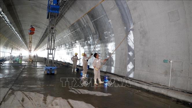 Công nhân thi công hạng mục sơn lòng hầm. Ảnh: Hữu Quyết - TTXVN