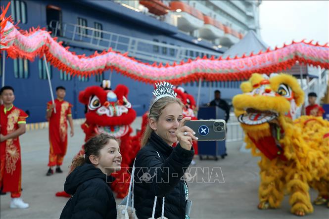 Visitors take a photo with the lion dance at a welcome ceremony at Ha Long International Cruise Port on January 1 morning. VNA Photo