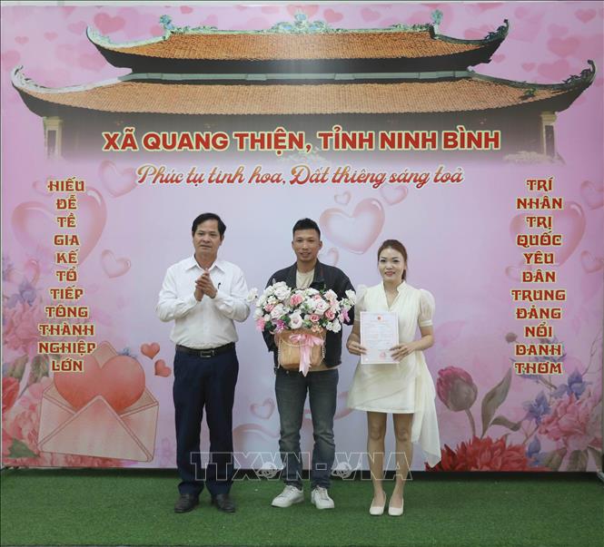 Đại diện UBND xã Quang Thiện trao giấy chứng nhận kết hôn tại Trung tâm phục vụ hành chính công. Ảnh: Thùy Dung - TTXVN