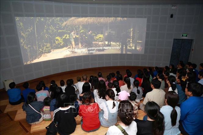 Du khách xem chiếu phim lịch sử tại Khu Di tích Địa đạo Củ Chi (xã An Nhơn Tây). Ảnh: Thu Hương - TTXVN             