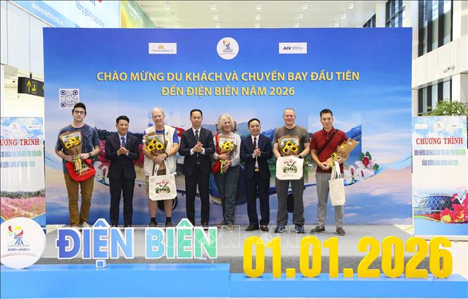 Lãnh đạo tỉnh Điện Biên tặng hoa và quà lưu niệm cho những hành khách trên chuyến bay đầu tiên đến Điện Biên năm 2026. Ảnh: Xuân Tư - TTXVN