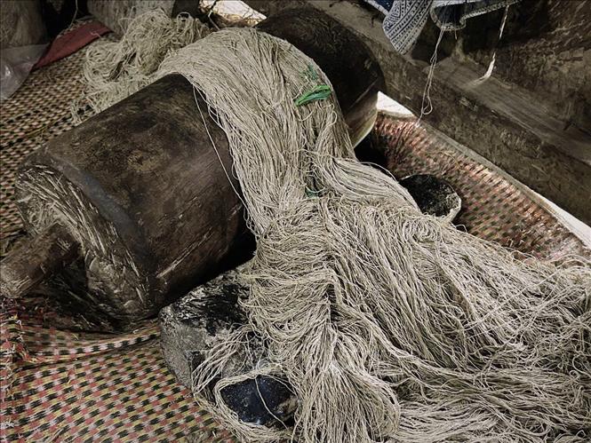 Linen threads being beaten on wood. VNA Photo: Phương Anh/Photo by courtesy