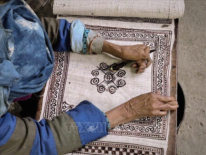 A Mong artisan carefully draws traditional patterns using beeswax on a piece of linen cloth. VNA Photo: Phương Anh/Photo by courtesy