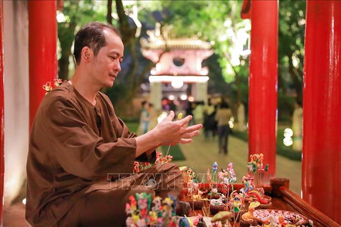 Các hoạt động trình diễn của các nghệ nhân làm nón, đan cói, thêu, nặn tò he kết hợp hài hòa với cảnh quan kiến trúc và lịch sử của Văn Miếu - Quốc Tử Giám mang đến nhiều ấn tượng cho du khách. Ảnh: Khánh Hoà - TTXVN