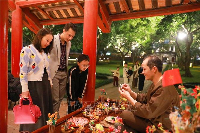 Các hoạt động trình diễn của các nghệ nhân làm nón, đan cói, thêu, nặn tò he kết hợp hài hòa với cảnh quan kiến trúc và lịch sử của Văn Miếu - Quốc Tử Giám mang đến nhiều ấn tượng cho du khách. Ảnh: Khánh Hoà - TTXVN