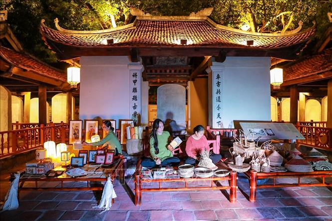 Các hoạt động trình diễn của các nghệ nhân làm nón, đan cói, thêu, nặn tò he kết hợp hài hòa với cảnh quan kiến trúc và lịch sử của Văn Miếu - Quốc Tử Giám mang đến nhiều ấn tượng cho du khách. Ảnh: Khánh Hoà - TTXVN