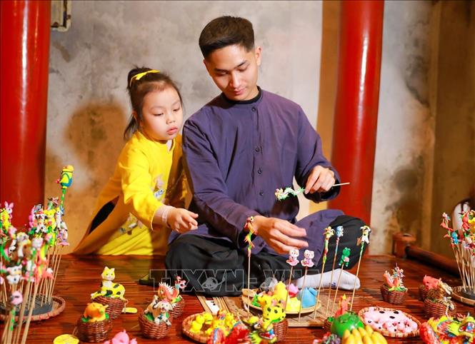 Các hoạt động trình diễn của các nghệ nhân làm nón, đan cói, thêu, nặn tò he kết hợp hài hòa với cảnh quan kiến trúc và lịch sử của Văn Miếu - Quốc Tử Giám mang đến nhiều ấn tượng cho du khách. Ảnh: Khánh Hoà - TTXVN