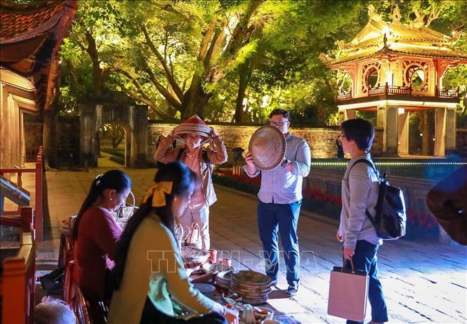 Các hoạt động trình diễn của các nghệ nhân làm nón, đan cói, thêu, nặn tò he kết hợp hài hòa với cảnh quan kiến trúc và lịch sử của Văn Miếu - Quốc Tử Giám mang đến nhiều ấn tượng cho du khách. Ảnh: Khánh Hoà - TTXVN