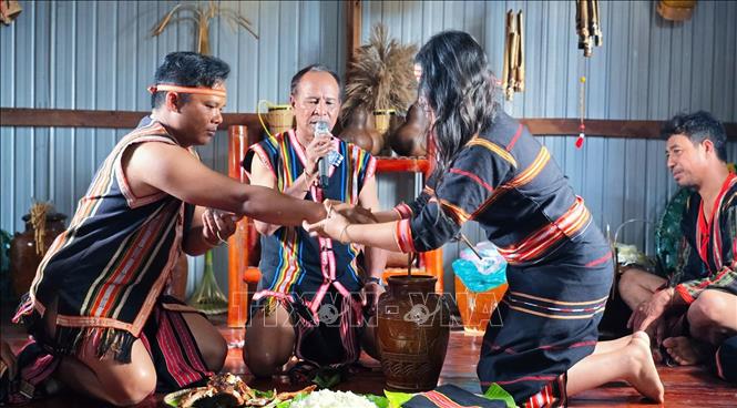 Nghi thức đeo vòng đồng đính ước - thể hiện lời ước hẹn bền chặt của đôi trai gái tại Lễ cầu hôn (Lễ ăn hỏi) của người Jrai tại tỉnh Gia Lai. Ảnh: Hồng Điệp - TTXVN