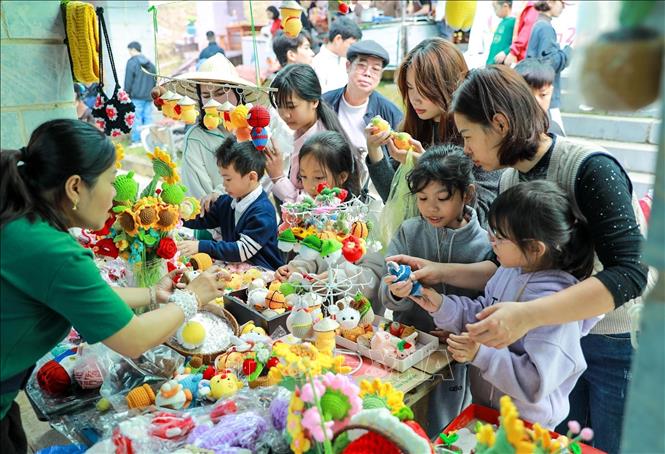 Du khách mua hàng tại Chợ phiên vùng cao - Chào năm mới 2026. Ảnh: Khánh Hoà - TTXVN