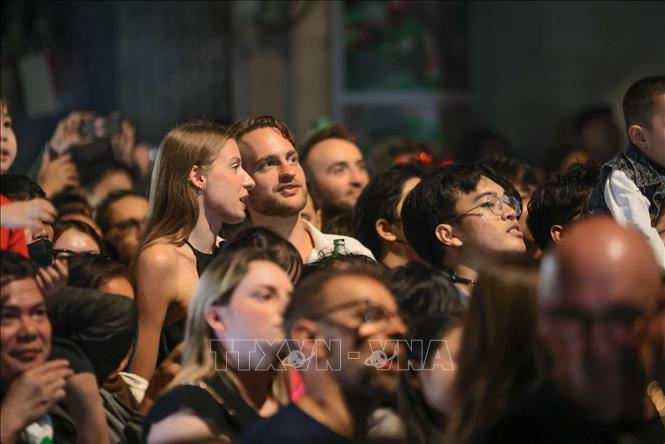 Foreign tourists join Hanoians to enjoy firework displays to celebrate New Year 2026. VNA Photo