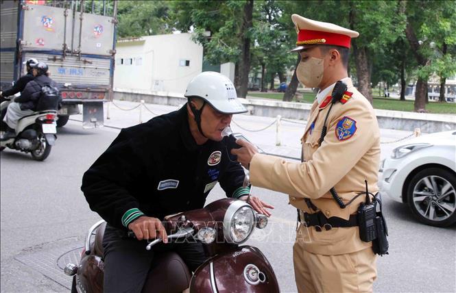 Cán bộ, chiến sĩ đội CSGT số 4 kiểm tra nồng độ cồn với các chủ phương tiện tham gia giao thông tại tuyến phố Nguyễn Đình Chiểu. Ảnh: Phạm Kiên - TTXVN 