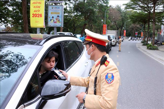 Cán bộ, chiến sĩ đội CSGT số 4 kiểm tra nồng độ cồn với các chủ phương tiện tham gia giao thông tại tuyến phố Nguyễn Đình Chiểu. Ảnh: Phạm Kiên - TTXVN 