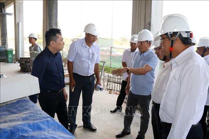 Đoàn công tác nghe báo cáo tiến độ xây dựng khu nhà ở công nhân phục vụ cho khu công nghiệp Hàm Kiệm II. Ảnh: Nguyễn Thanh - TTXVN