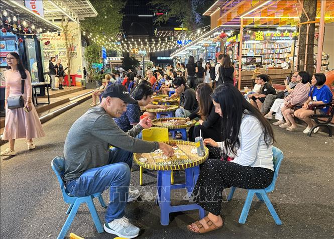 Trò chơi ô ăn quan được nhiều người dân, du khách tham gia. Ảnh: Thu Hương - TTXVN