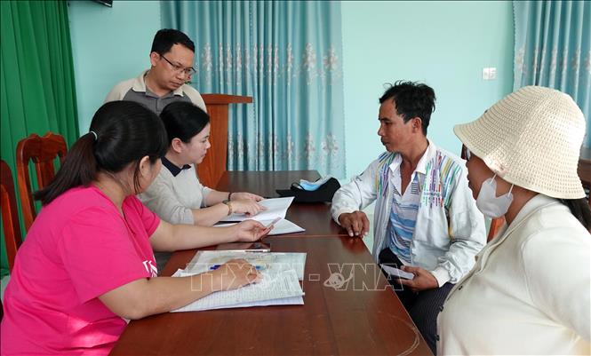 Cán bộ phòng văn hóa xã Thuận Nam rà soát danh sách để phát quà cho đối tượng thụ hưởng theo Nghị quyết số 418 của Chính phủ. Ảnh: Công Thử - TTXVN