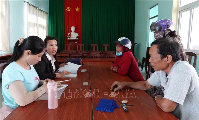 Cán bộ phòng văn hóa xã Thuận Nam chi trả quà 418 của Chính phủ cho các đối tượng thụ hưởng ở địa phương. Ảnh: Công Thử - TTXVN