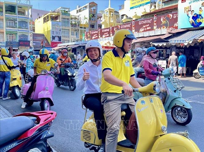 Du khách hào hứng trải nghiệm du lịch Thành phố Hồ Chí Minh bằng xe Vespa. Ảnh: Mỹ Phương – TTXVN