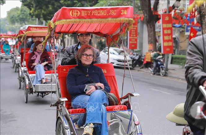 Du khách nước ngoài thích thú với khí hậu mát lạnh và trải nghiệm đi xích lô giữa không gian Thủ đô yên bình. Ảnh: Phan Phương – TTXVN
