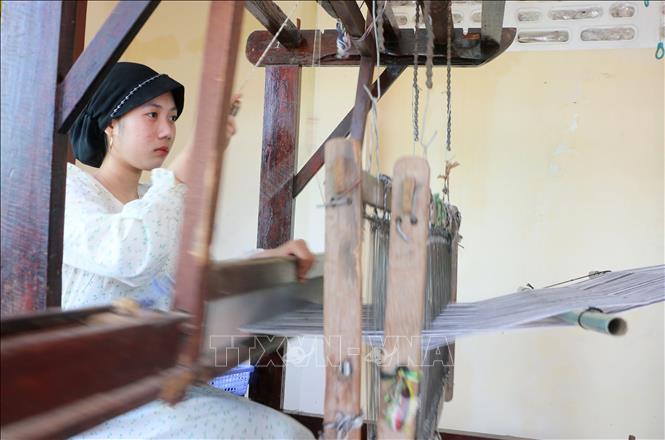 Ngày ngày, những người phụ nữ Chăm ở Châu Phong vẫn khéo léo dệt nên những tấm thổ cẩm thủ công rất riêng biệt, mang đậm văn hóa Chăm. Ảnh: Công Mạo-TTXVN