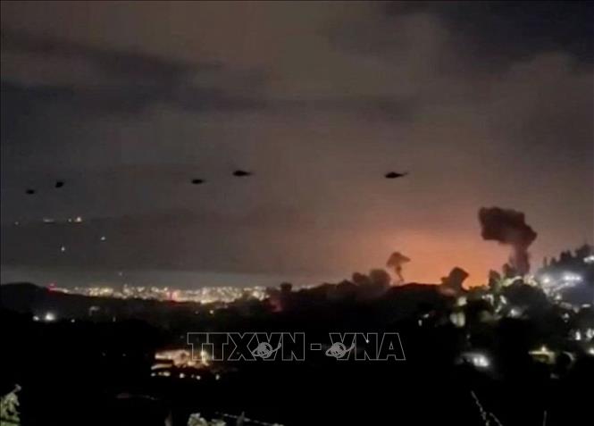 Trực thăng bay qua khu vực khói bốc lên từ loạt vụ nổ ở thủ đô Caracas, Venezuela, ngày 3/1/2026. Ảnh: Reuters/TTXVN