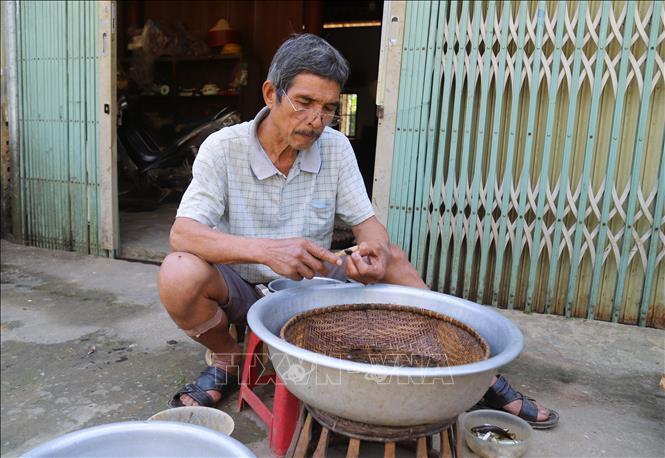  Người dân Ơ Đu ở bản Văng Môn (xã Nga My, tỉnh Nghệ An) đang sơ chế cá suối để làm món “moọc” truyền thống cho người thân mang ra bán ở chợ phiên Nga My. Ảnh: Xuân Tiến - TTXVN  